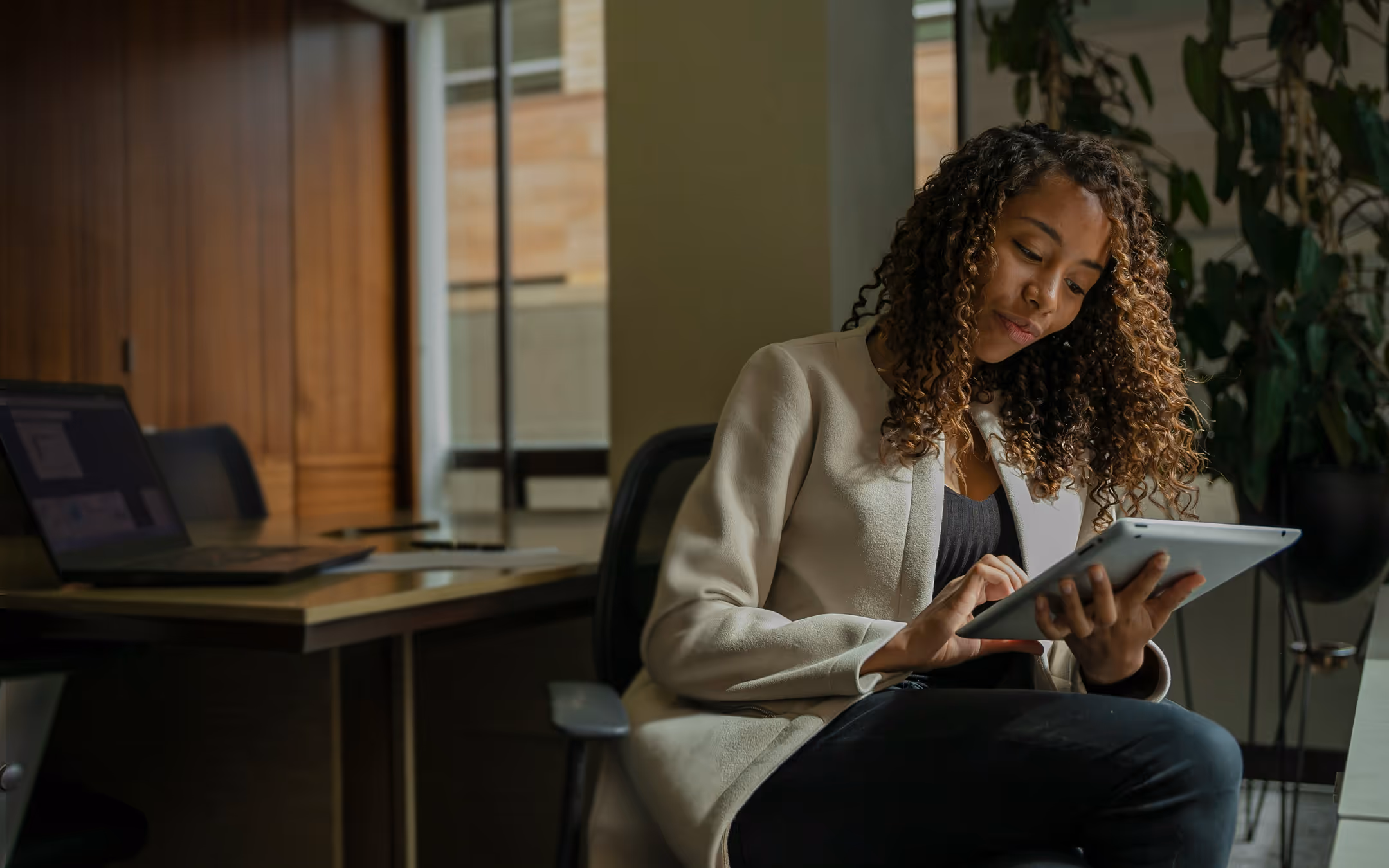 Buyer reviewing a vendor evaluation on a laptop in a bright modern office.